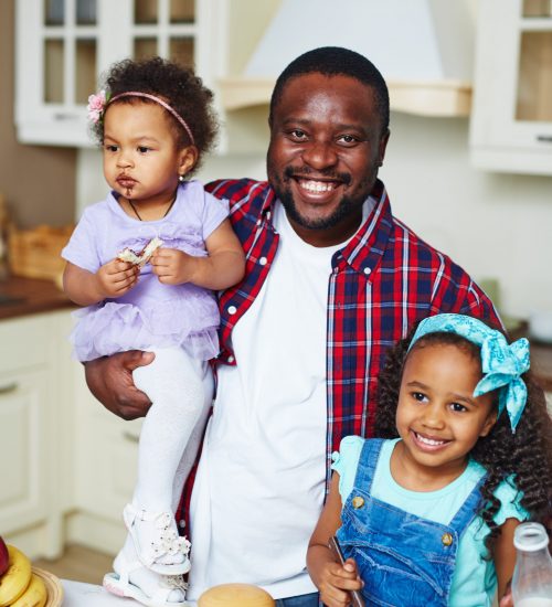 Family of father and two daughters in the kitchen